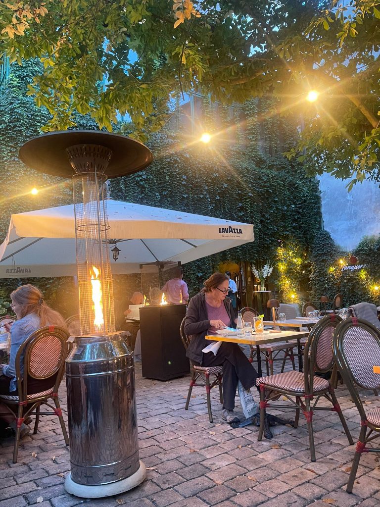 Outdoor restaurant seating area in Krakow, with big fire lamps to warm and keep the area lit. Romantic scene, luxurious restaurant. 