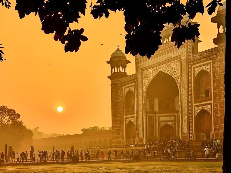 Taj Mahal in the sunset. The sunset illuminates the picture making the entire scene dusky orange. 