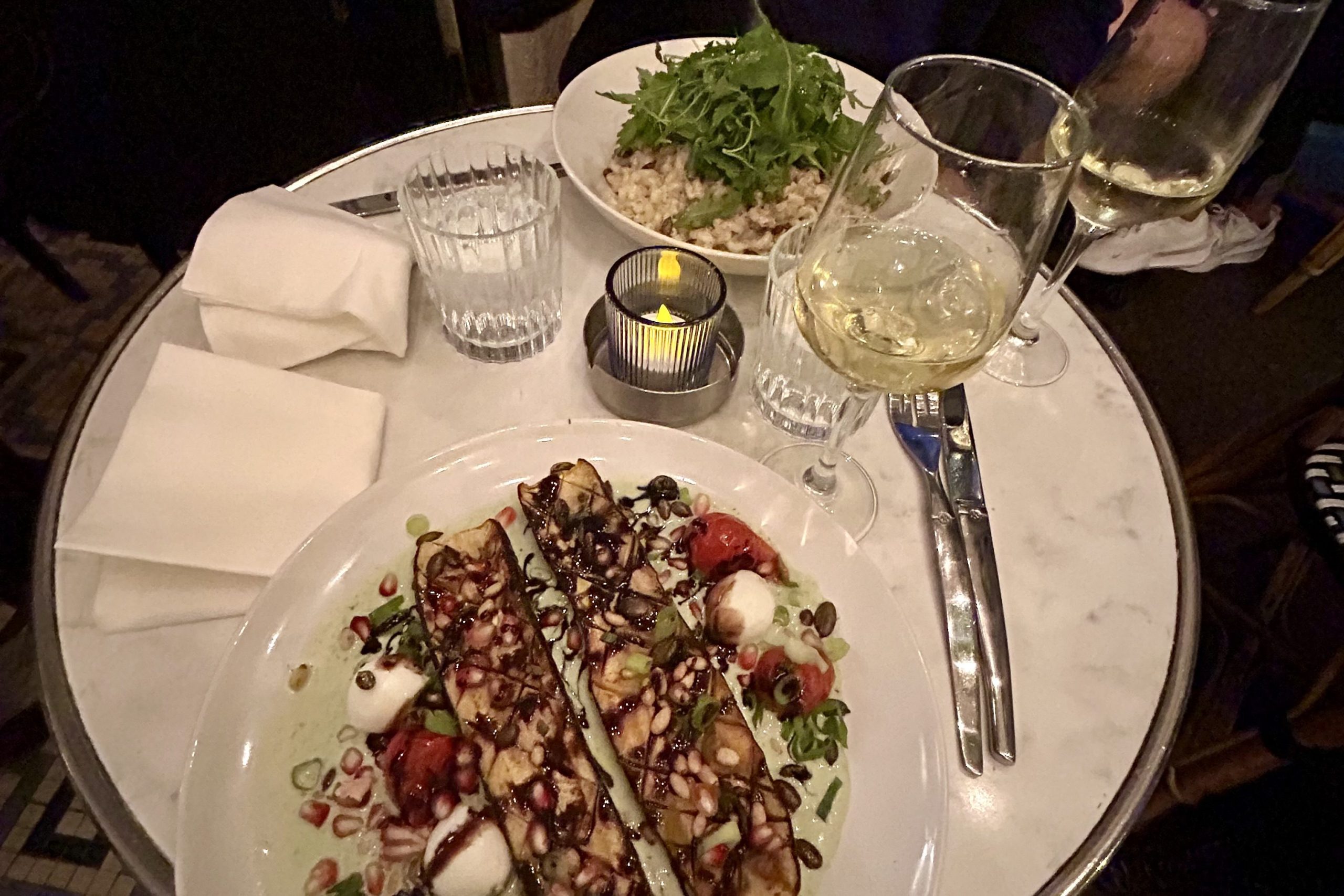 Two people having a candle lit dinner with wine in Paris. 